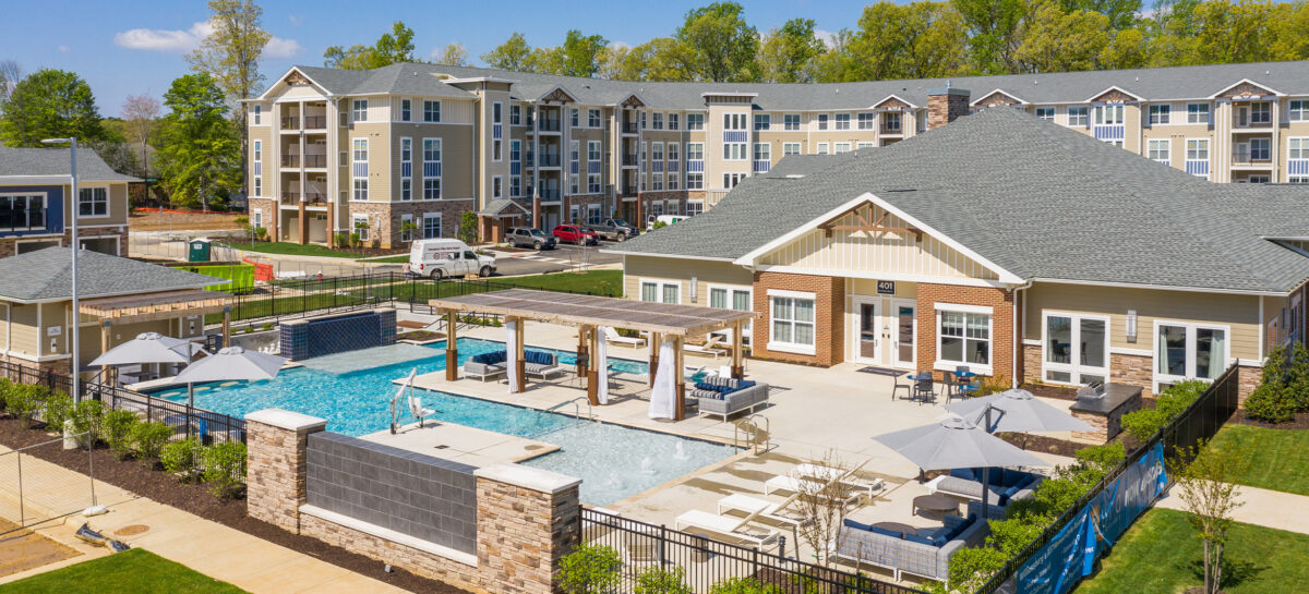 Exterior view of multifamily development with a pool