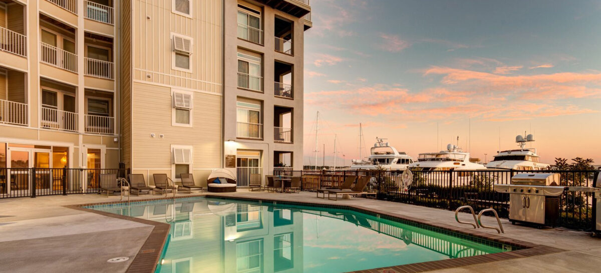 Sunset view of a pool and boats at a multifamily development
