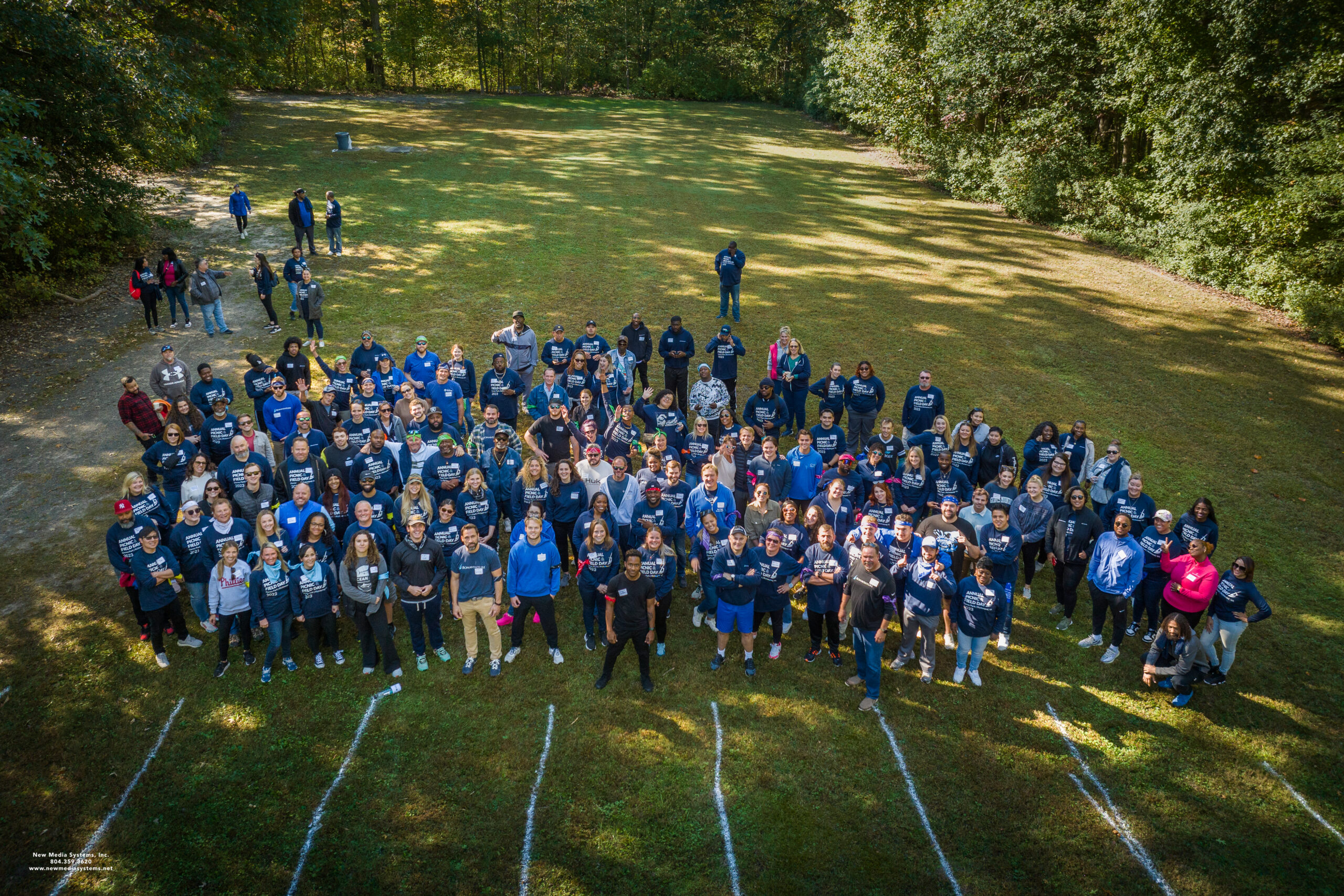 Overhead drone shot of group of people standing in grass
