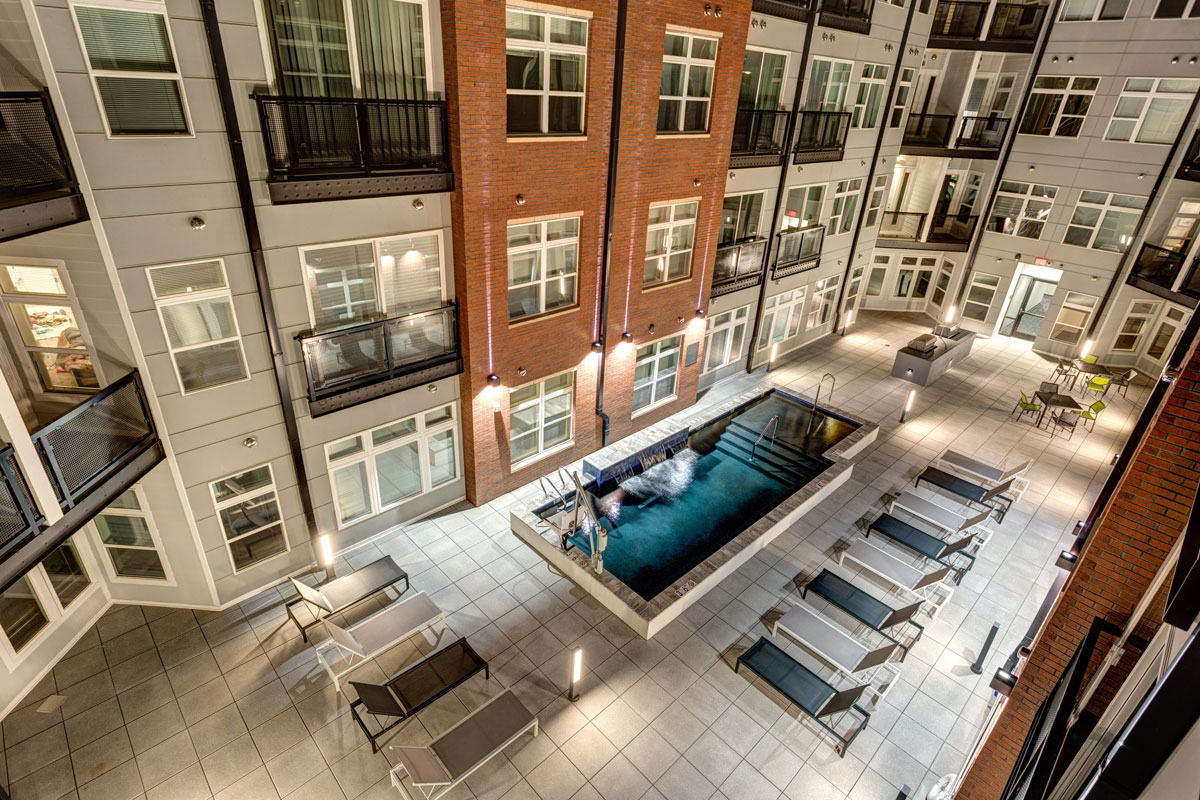 Nighttime view of pool area at multifamily development