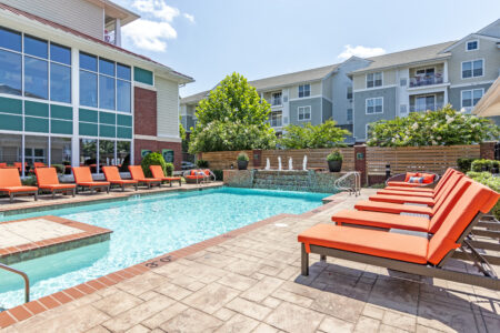Photo of a pool with a fountain and orange pool chairs