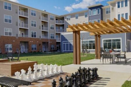 Photo of a large life size chess set and arbor with patio furniture